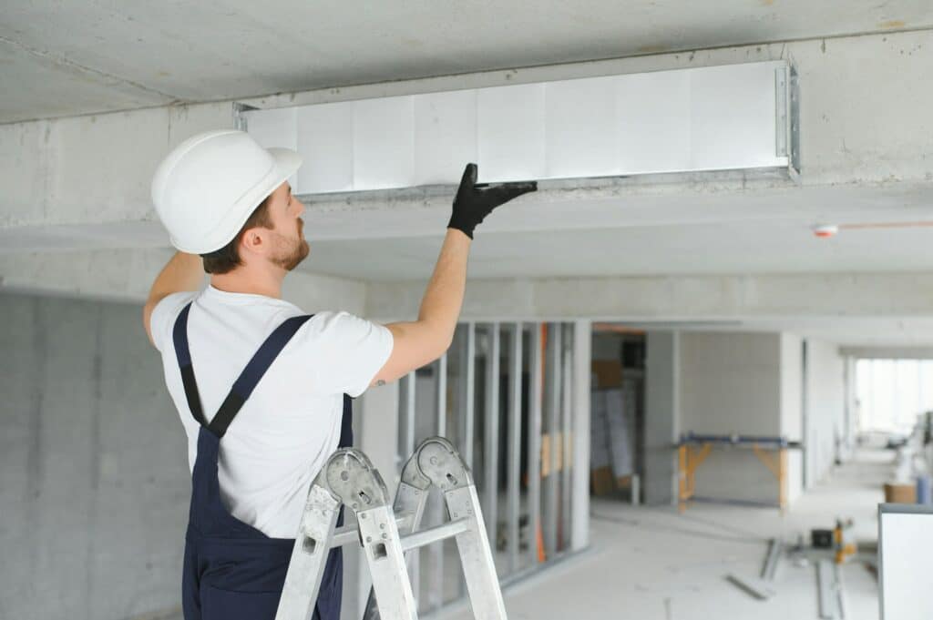 hvac services - worker install ducted pipe system for ventilation and air conditioning